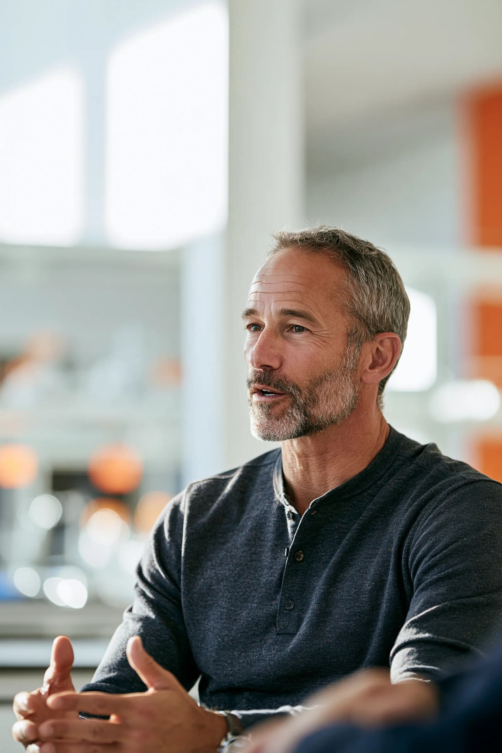 Man speaking and gesturing during a conversation in a bright workspace