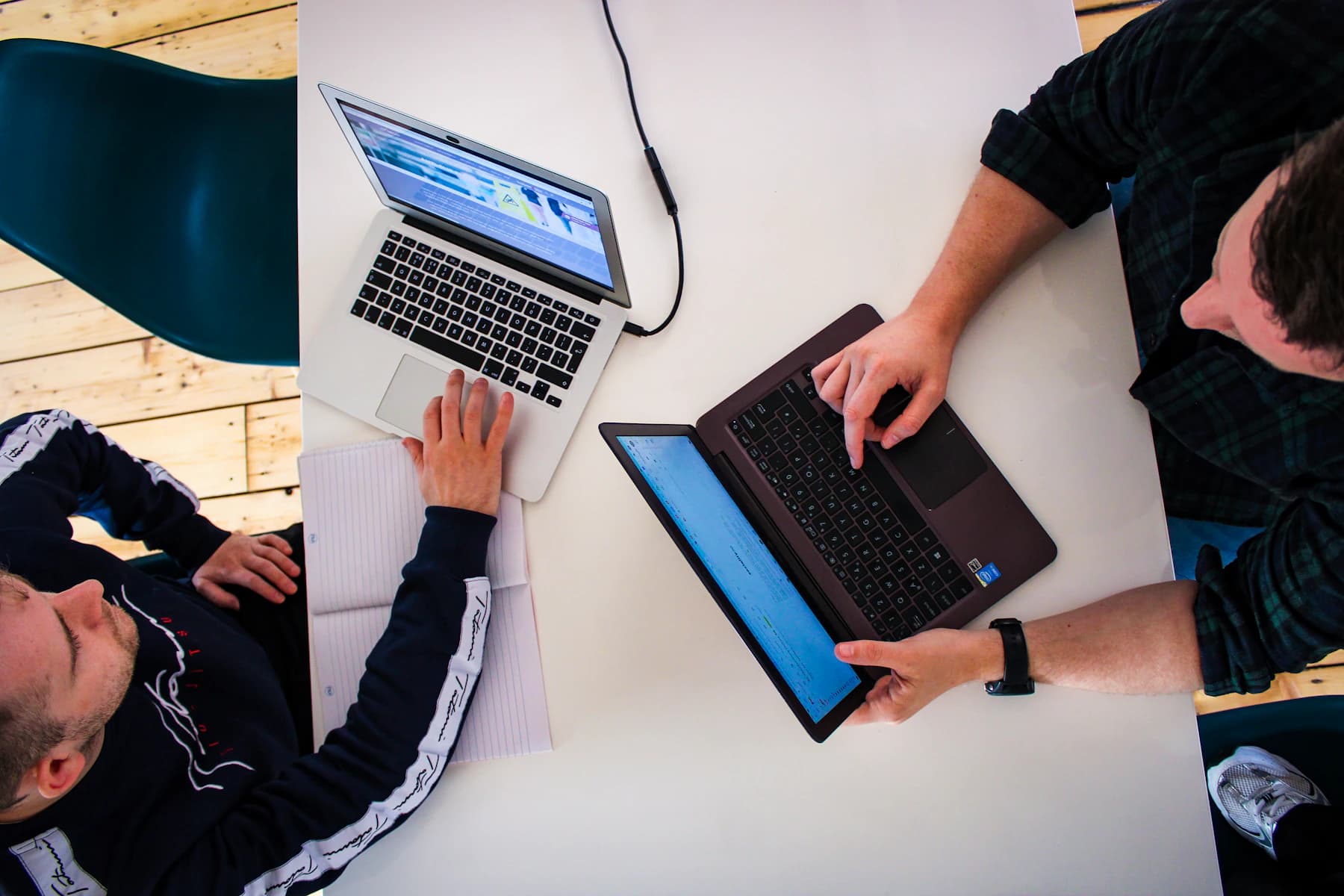Overhead photograph of two marketing colleagues reviewing work on laptops